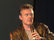 Anthony Head on a chair on stage