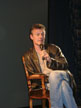 Anthony Head on a chair on stage